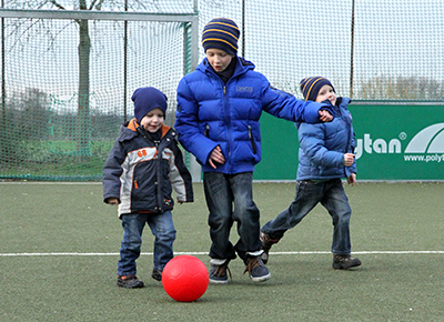 Drei Jungs spielen mit einem Ball
